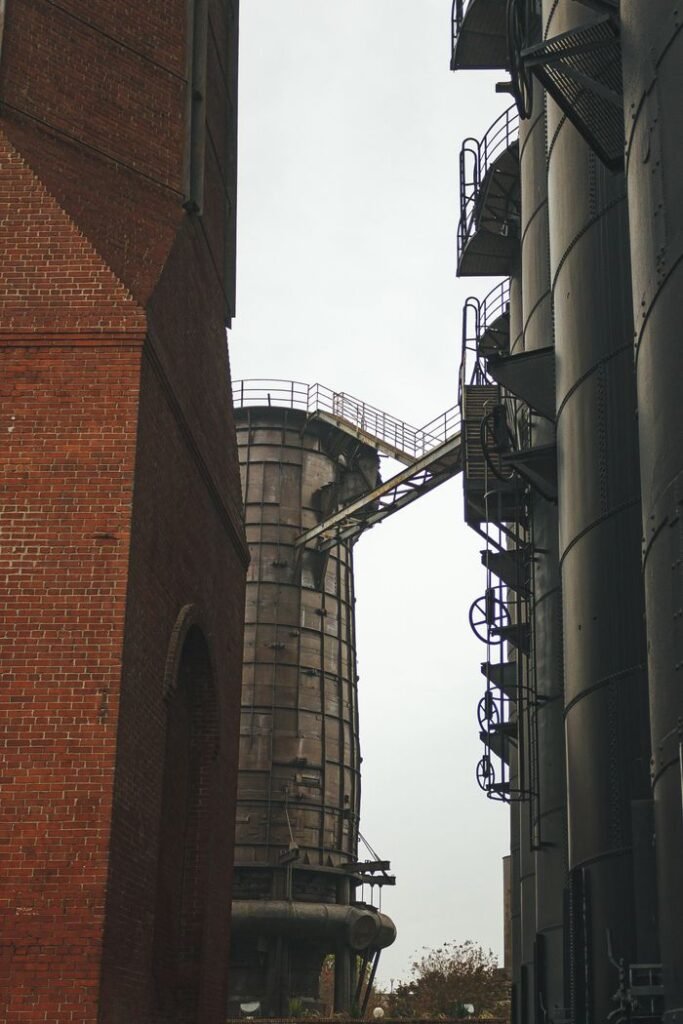 pexels-photo-11150871 Vertical view of brick and metal industrial towers in an urban setting.